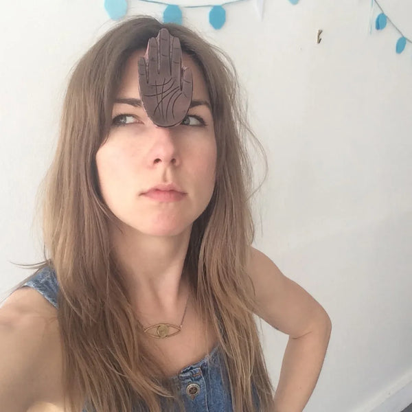 woman thinking pensively with a rubber hand on her forehead