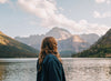 Woman looking over the water and mountain range.