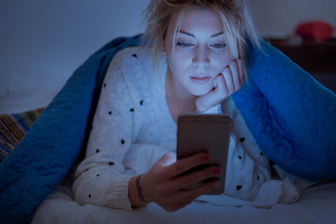 woman-on-phone-under-bed-sheet