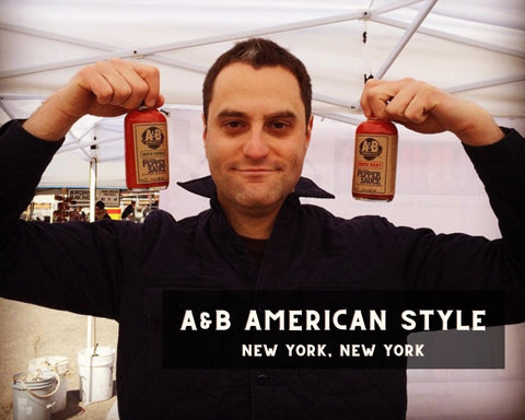 A&B American Style Hot Sauce Owner Holding Up Two Bottles of Hot Sauce