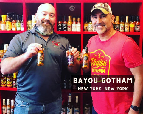 Two Bayou Gotham Founders Holding Up Bayou Gotham Hot Sauce