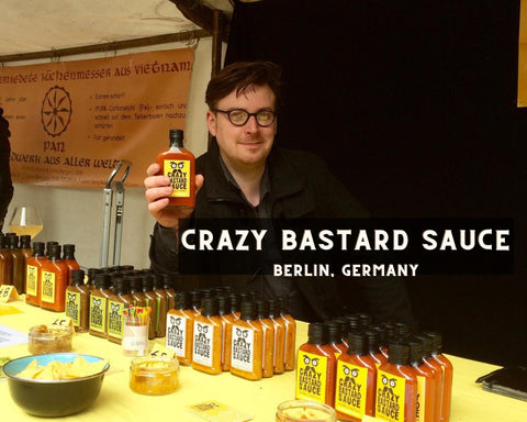 Crazy Bastard Sauce Founder Holding Up A Bottle of Crazy Bastard Hot Sauce