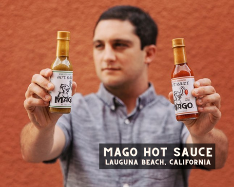 Mago Hot Sauce Owner Holding Up Two Hot Sauce Bottles