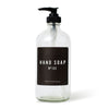 Clear glass refillable hand soap dispenser bottle with black label. 