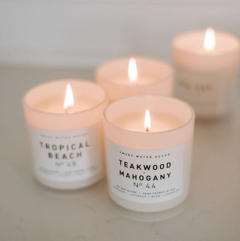White jar soy wax candles from sweet water decor in Teakwood and Mahogany and Tropical Beach scents. 