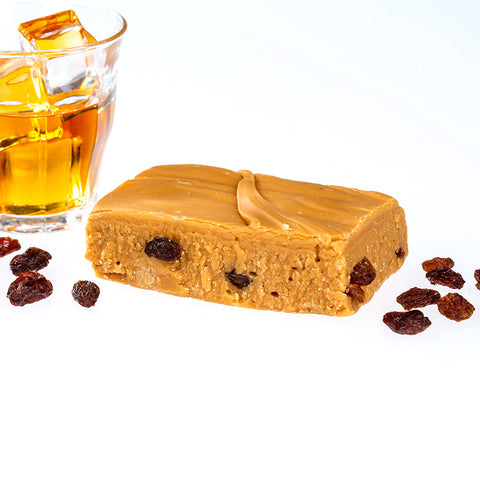 Handmade Fudge Surrounded by A clear glass of rum and raisins 