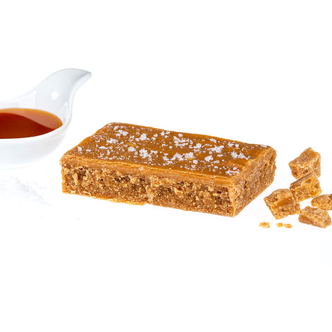 Bar of Ochil Fudge Salted Caramel Fudge surrounded by fudge pieces and caramel sauce