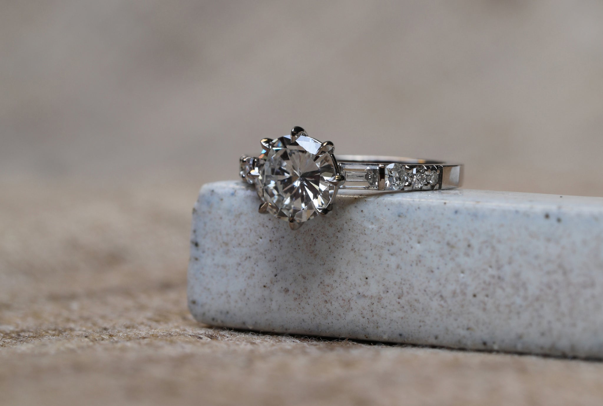 The client’s own heirloom diamond with Baguette and Round white diamond shoulders on a Platinum band.