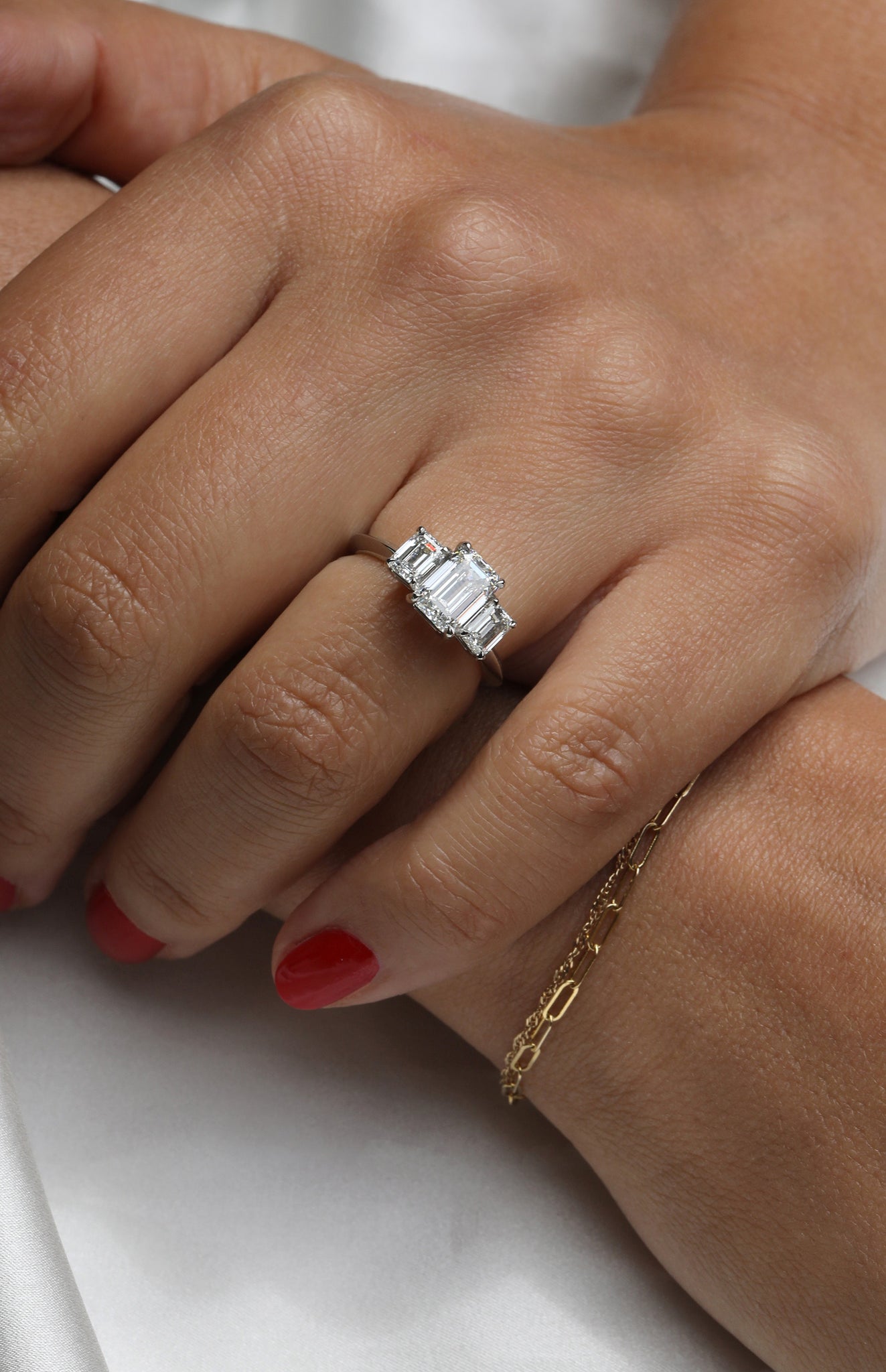 Emerald cut diamond trilogy engagement ring.
