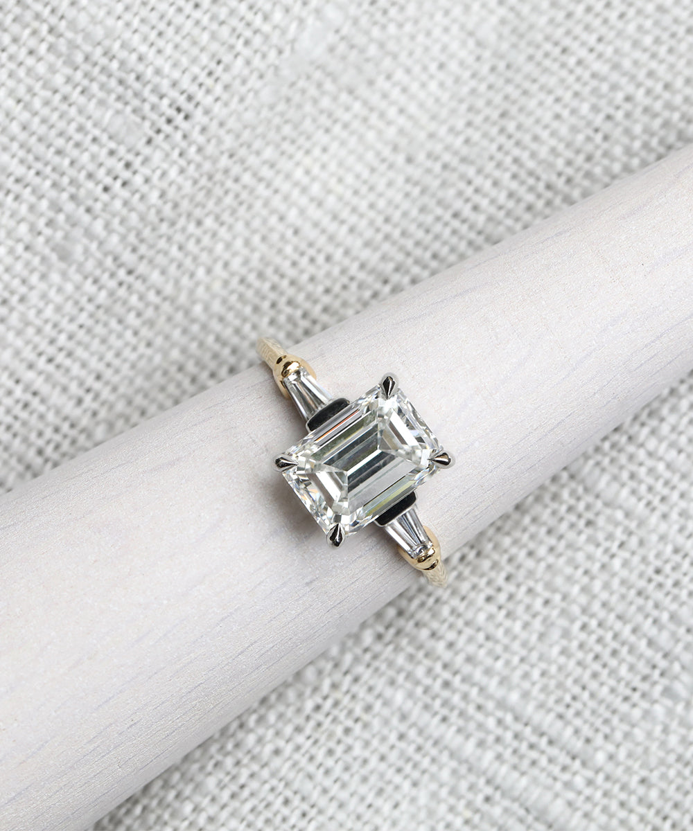 Emerald cut diamonds with tapered baguette diamonds creates a unique vintage-inspired engagement ring.
