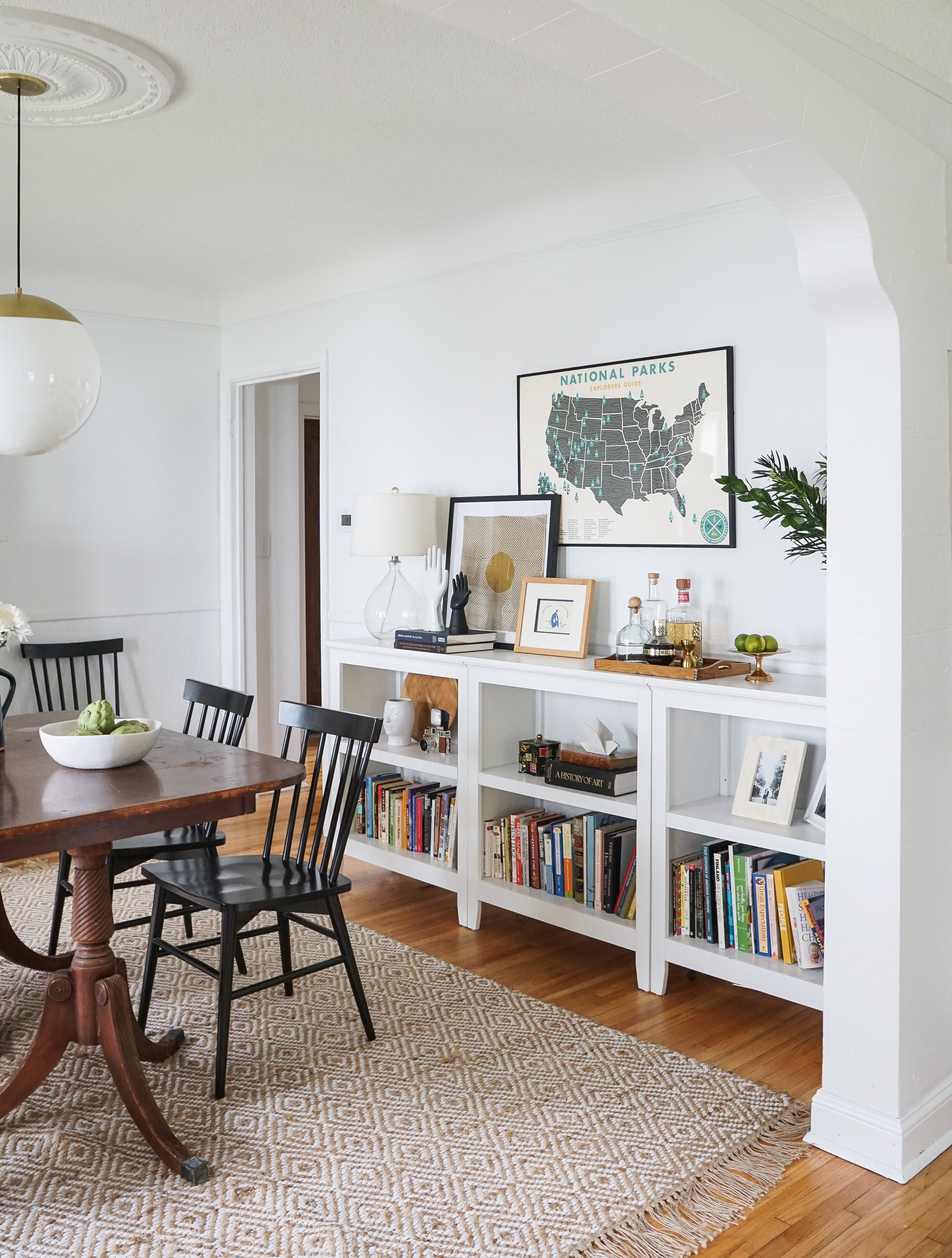 room with a table and chairs and white book shelf