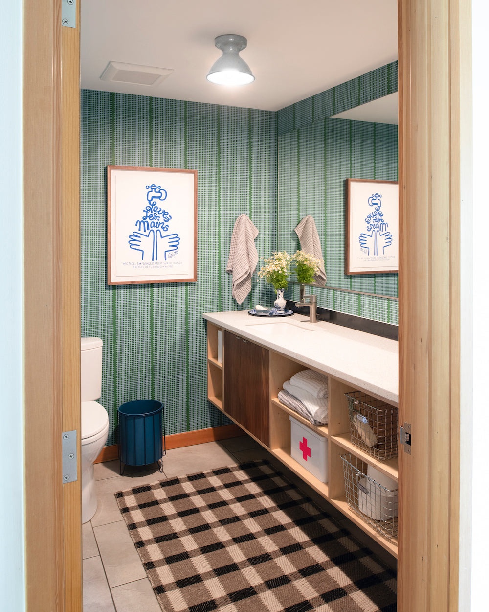 bathroom with a sink and a mirror and checkered rug