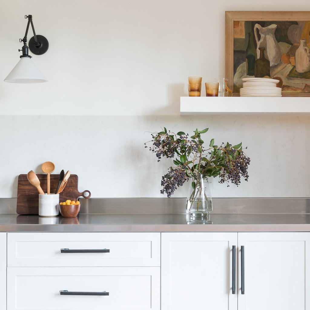 kitchen with white cabinets and vase of flowers on the counter