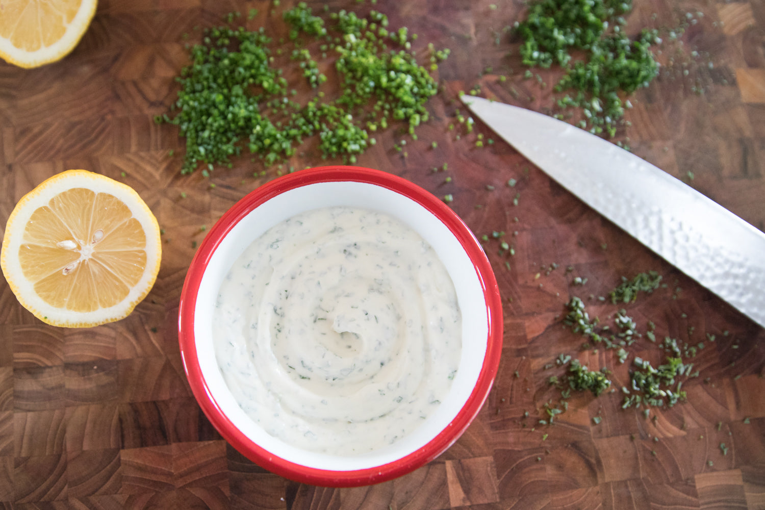 bowl of dip and lemon and herbs