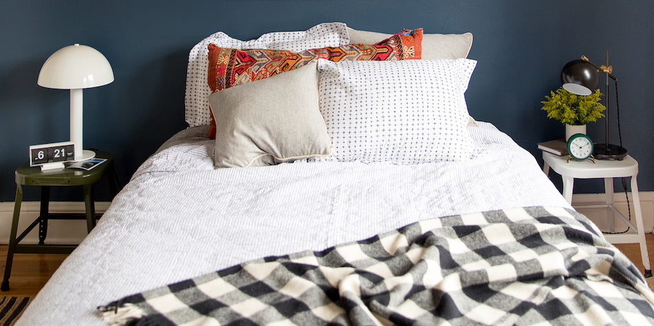 bed with a pillow and a gingham blanket