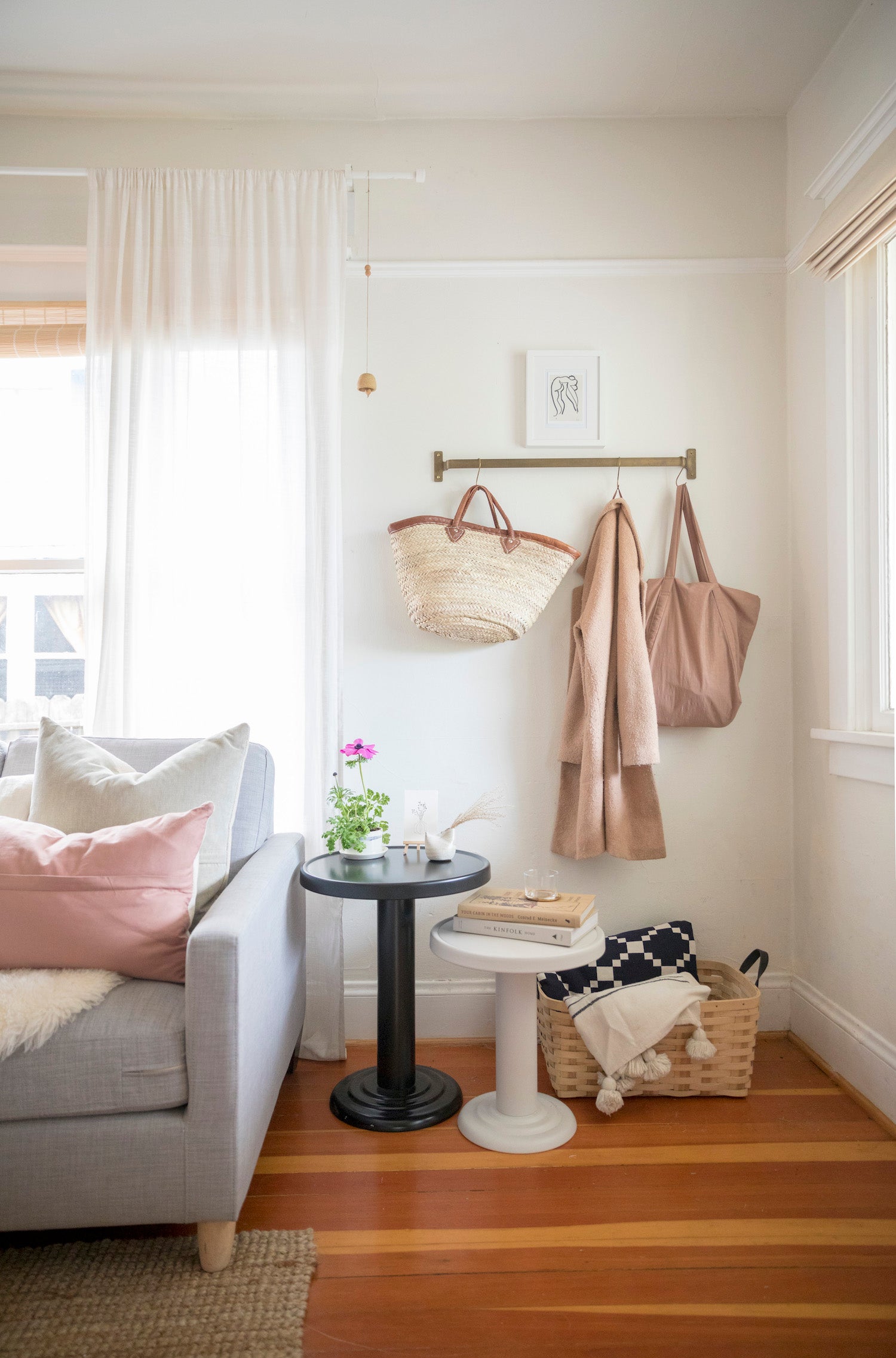 living room with two round side tables and bags hanging