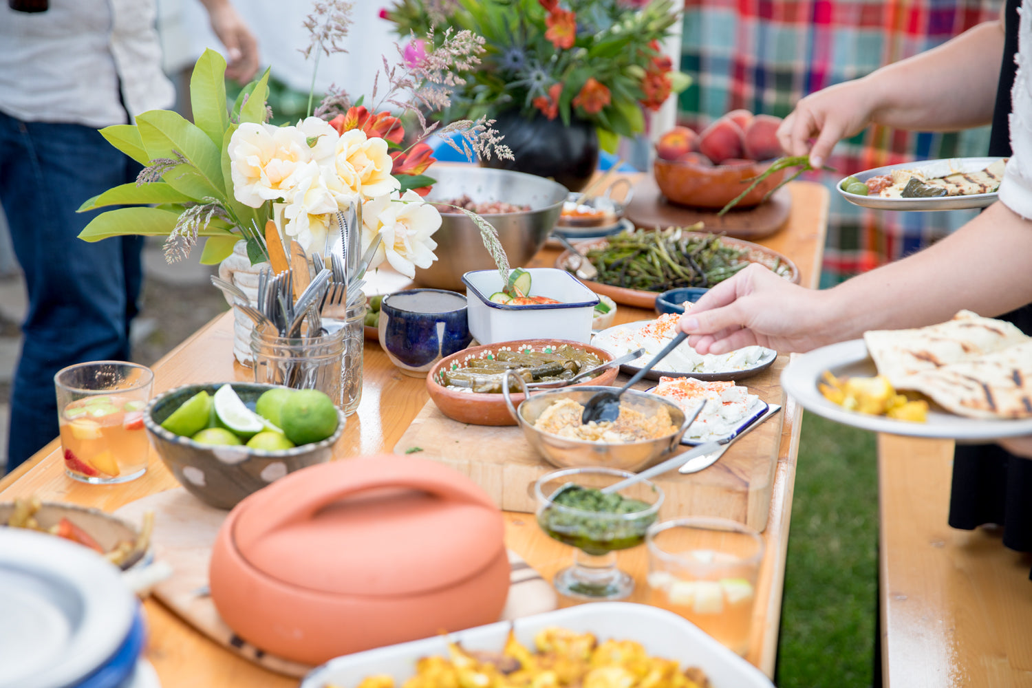 table full of food with people serving themselves