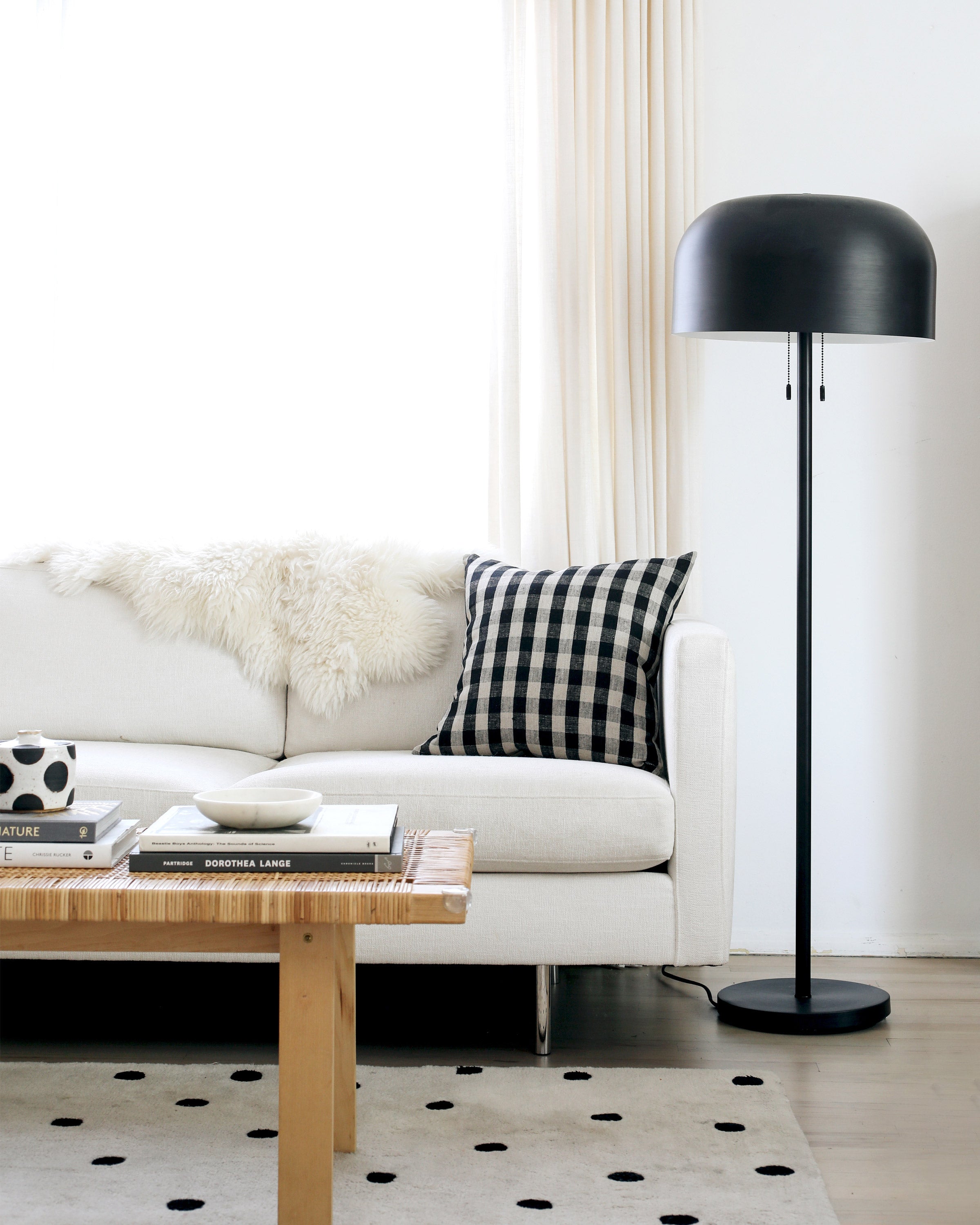 coffee table in a living room and a white couch and black floor lamp