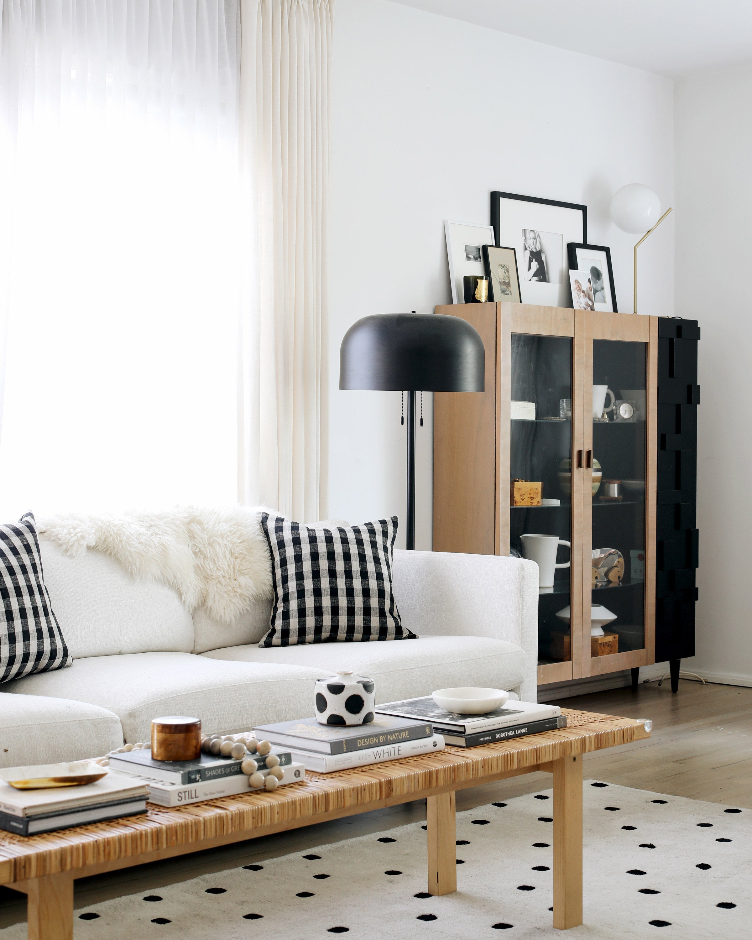white couch with a coffee table and a black floor lamp next to a cabinet