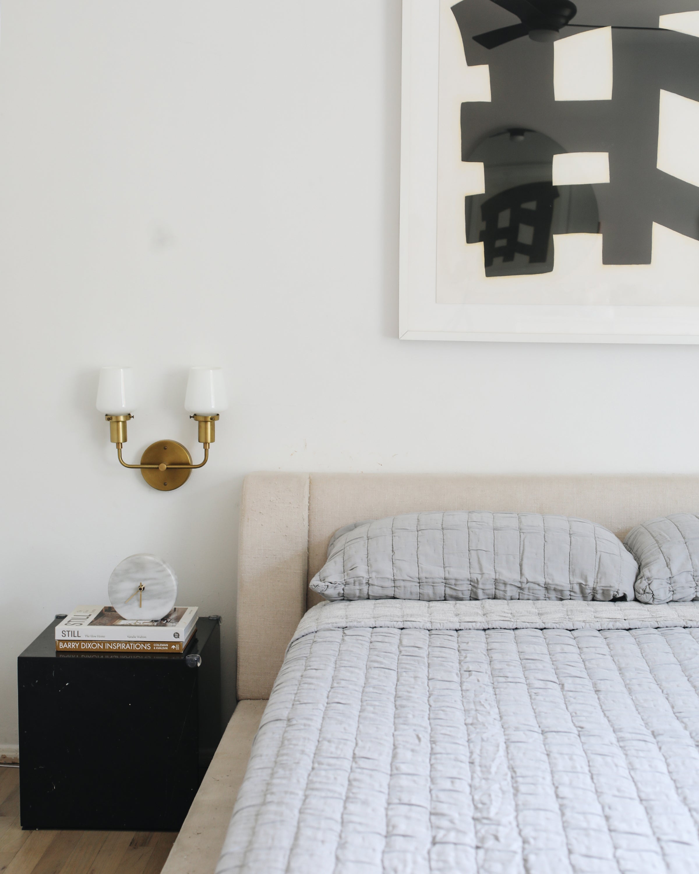 bed with a white comforter and black night stand