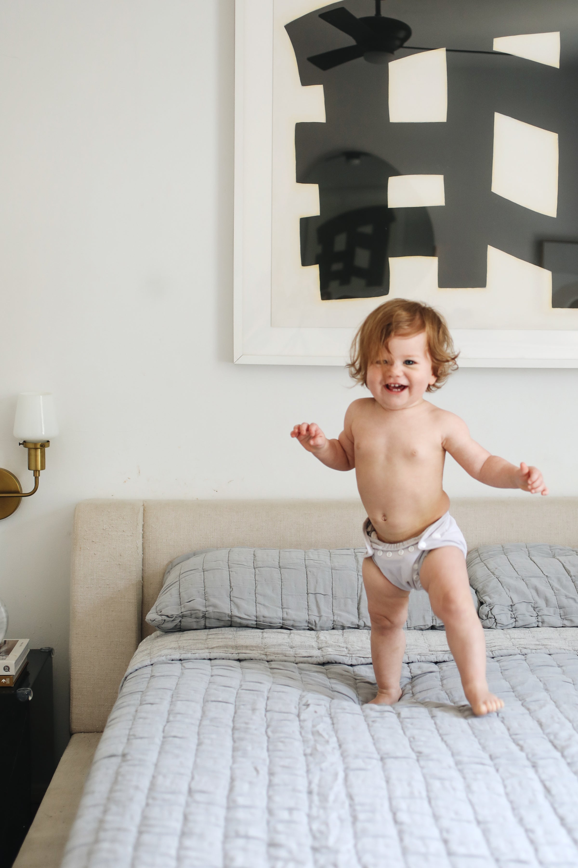 baby standing on a bed