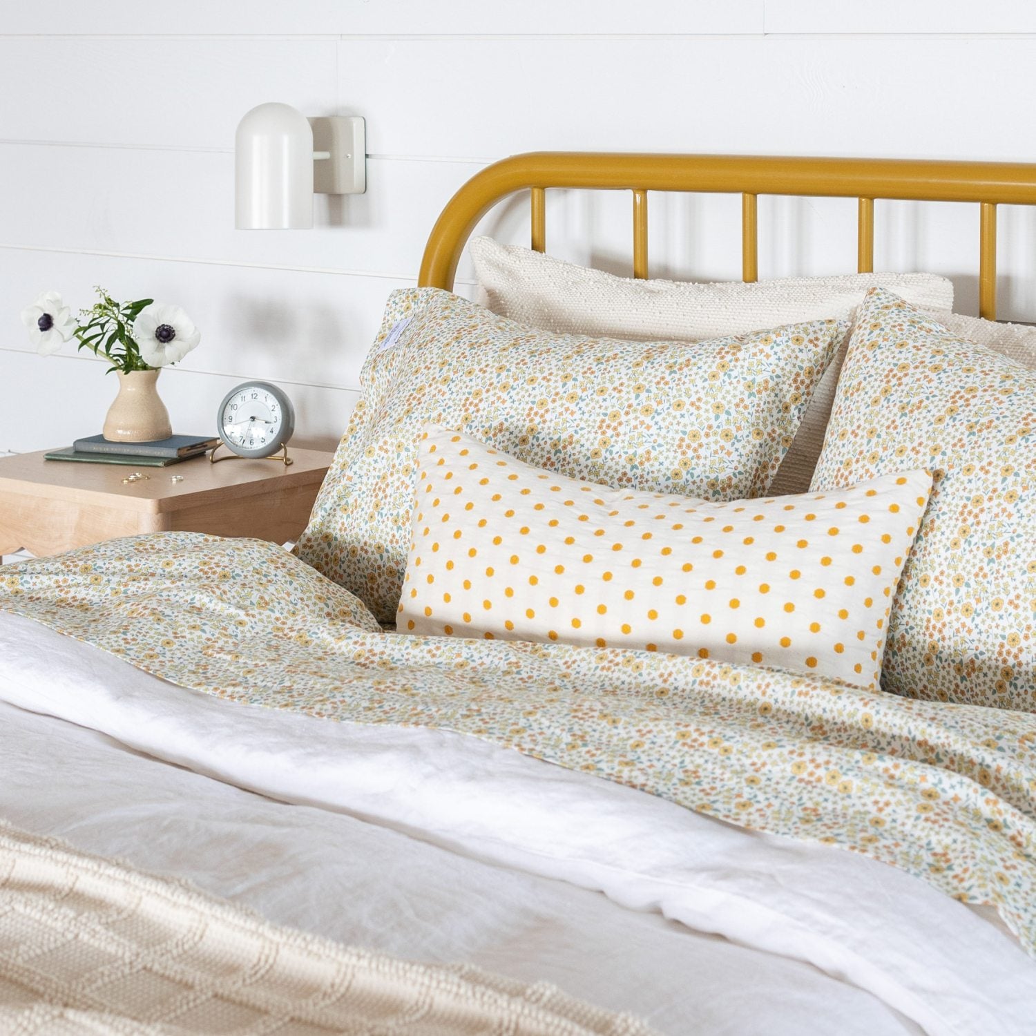 Floral bedding on metal wire frame bed. 