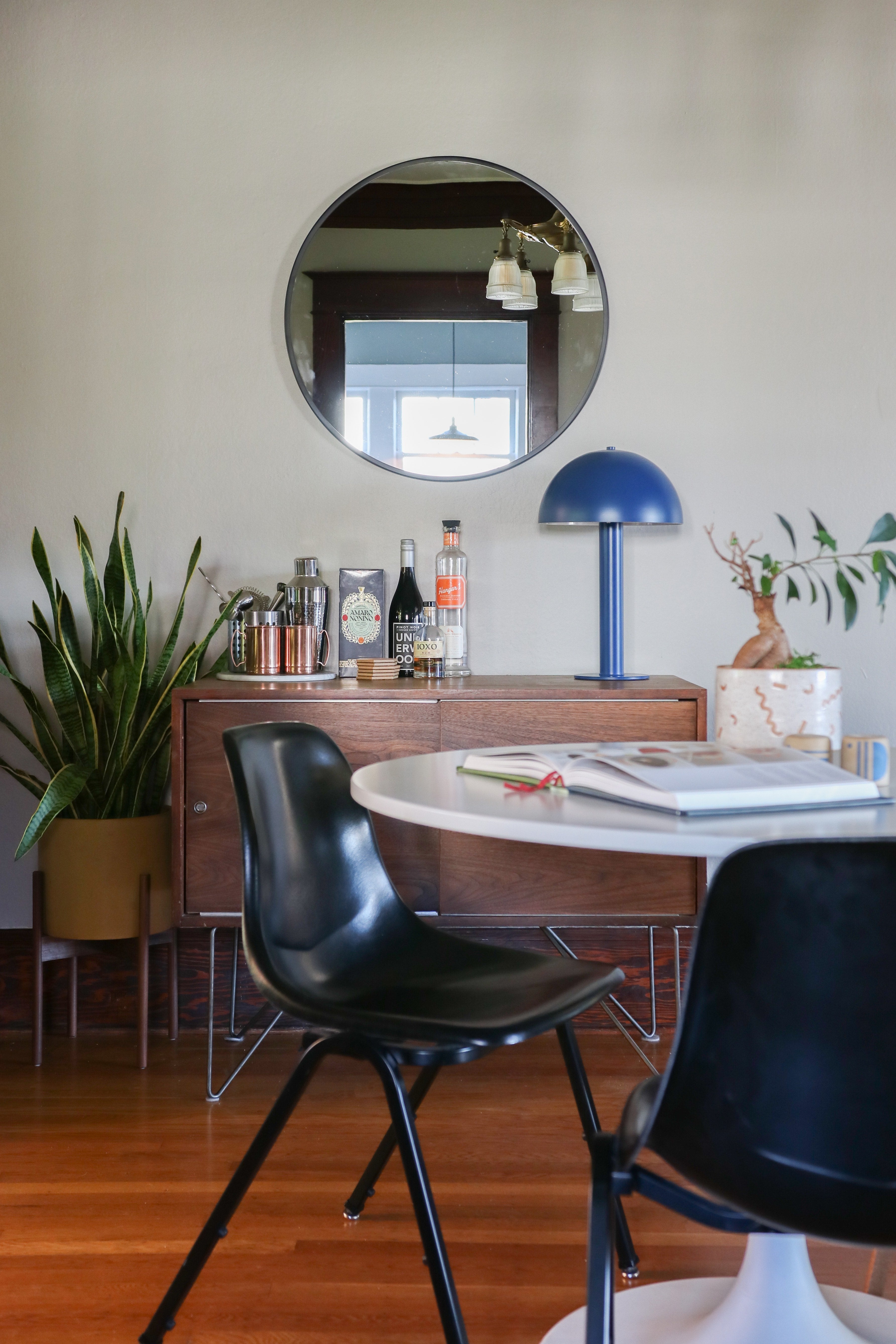 table with blue rounded lamp and mirror above it