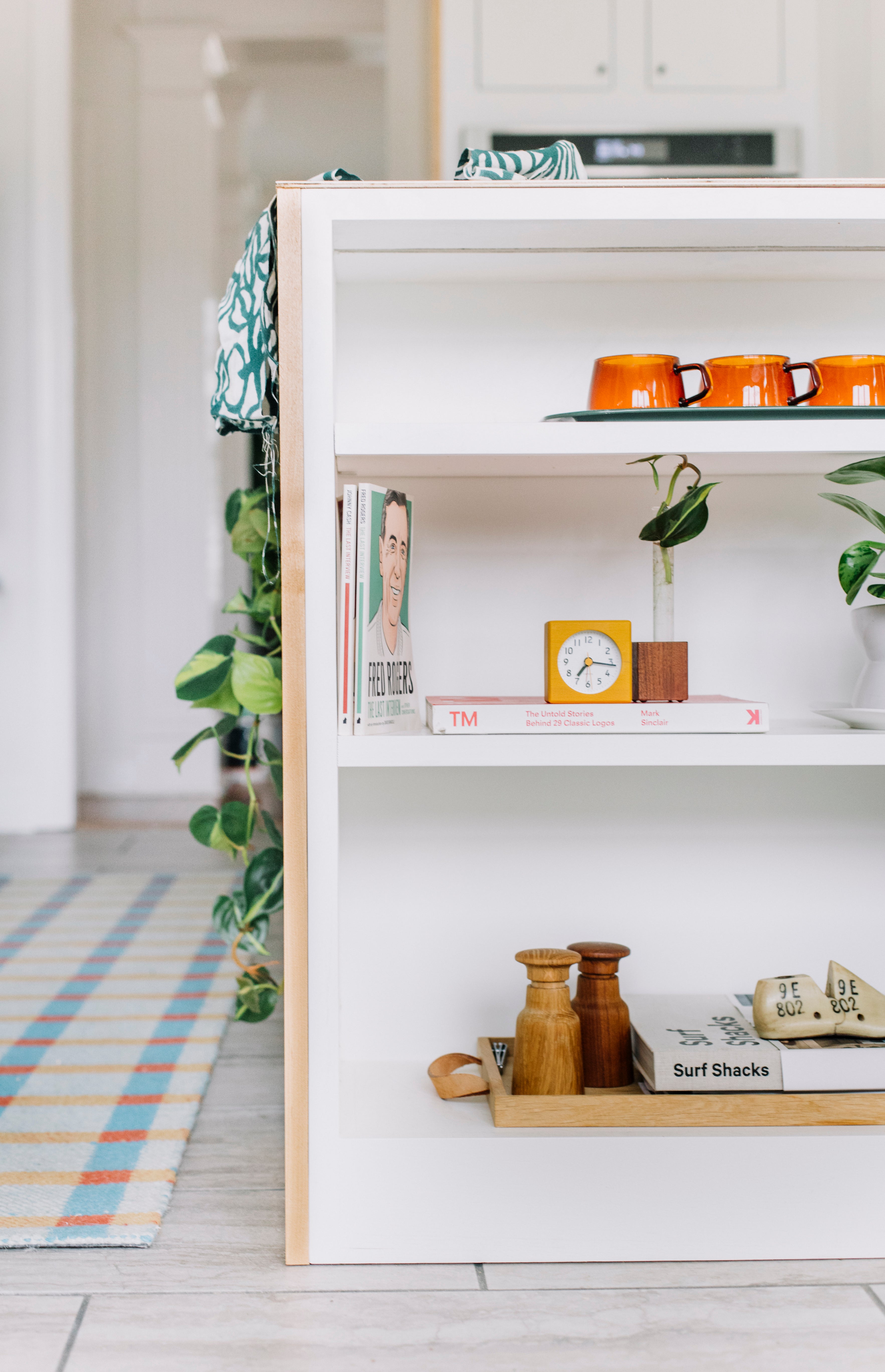 modern white kitchen island with colorful decor on shelves