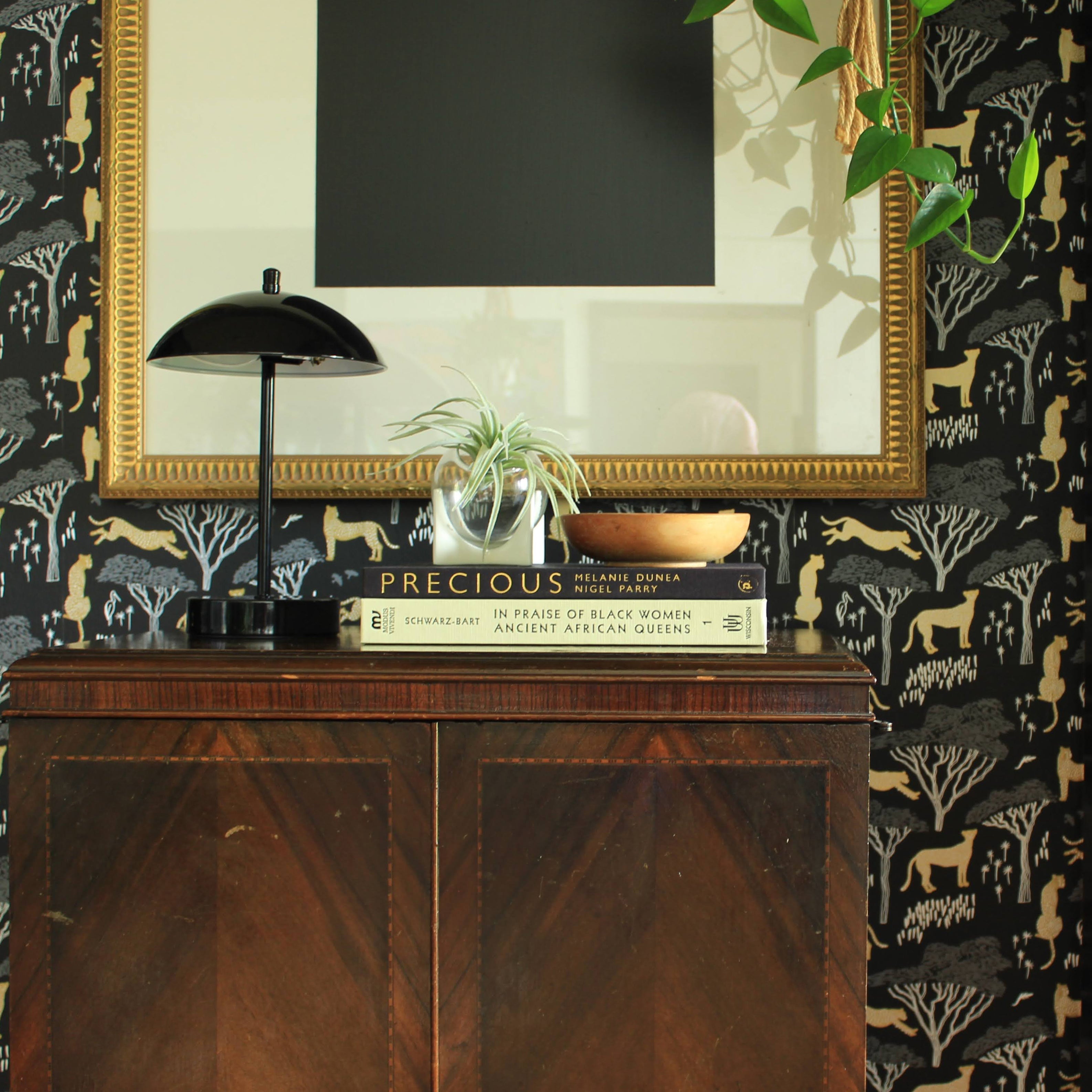 wallpapered entryway with black table lamp