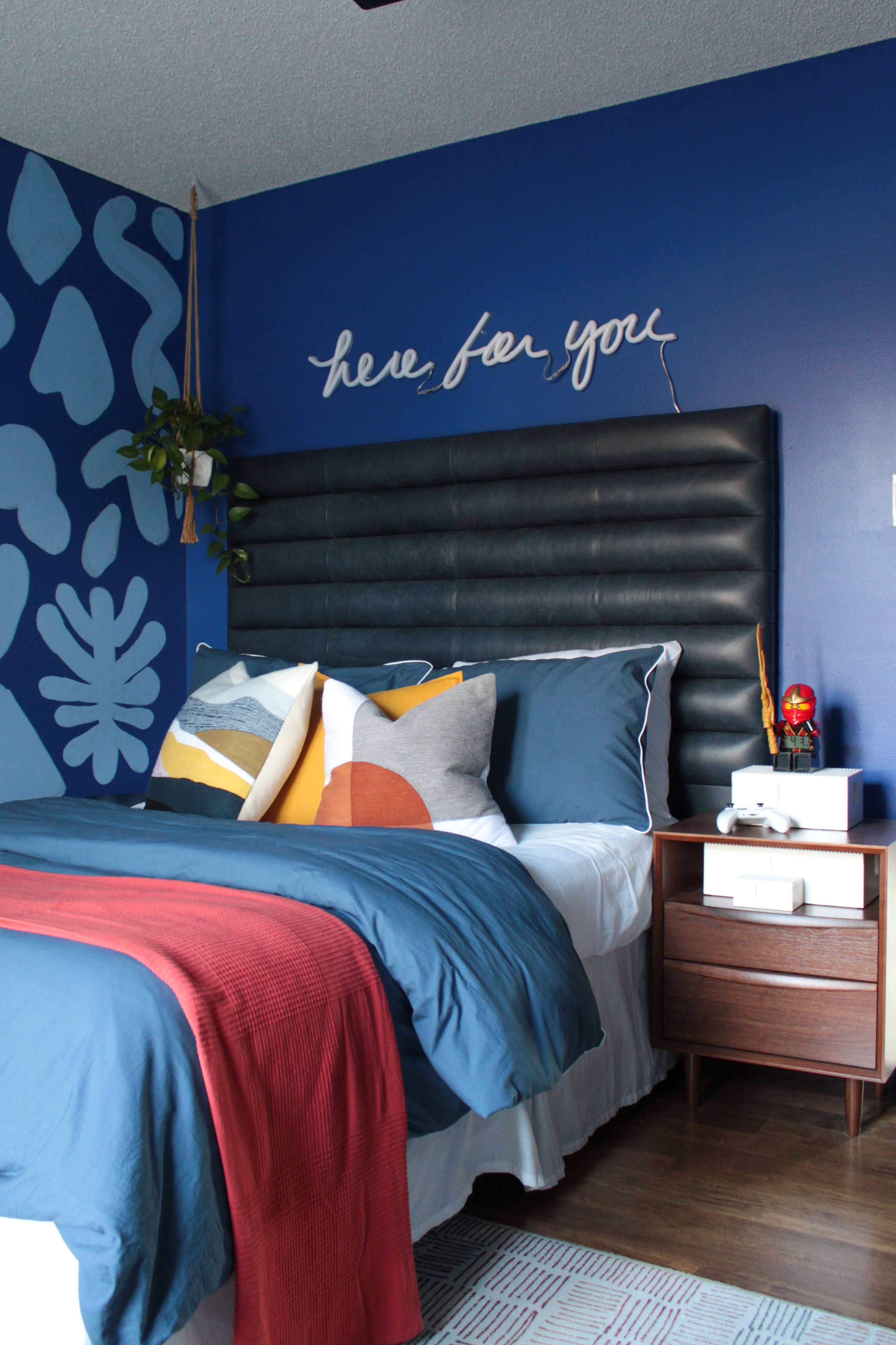 bed with a blue wall and red blanket