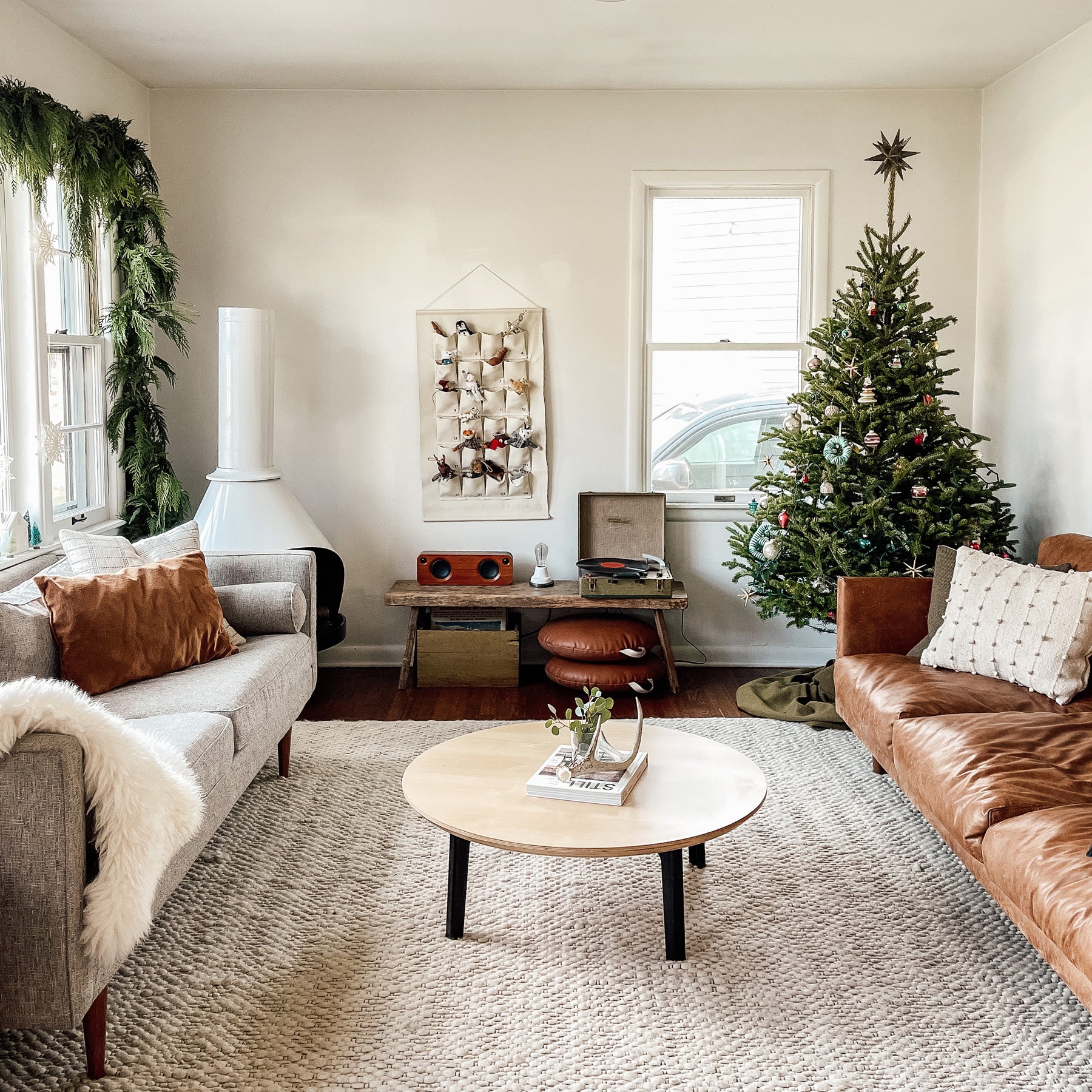 living room with a christmas tree and brown couch