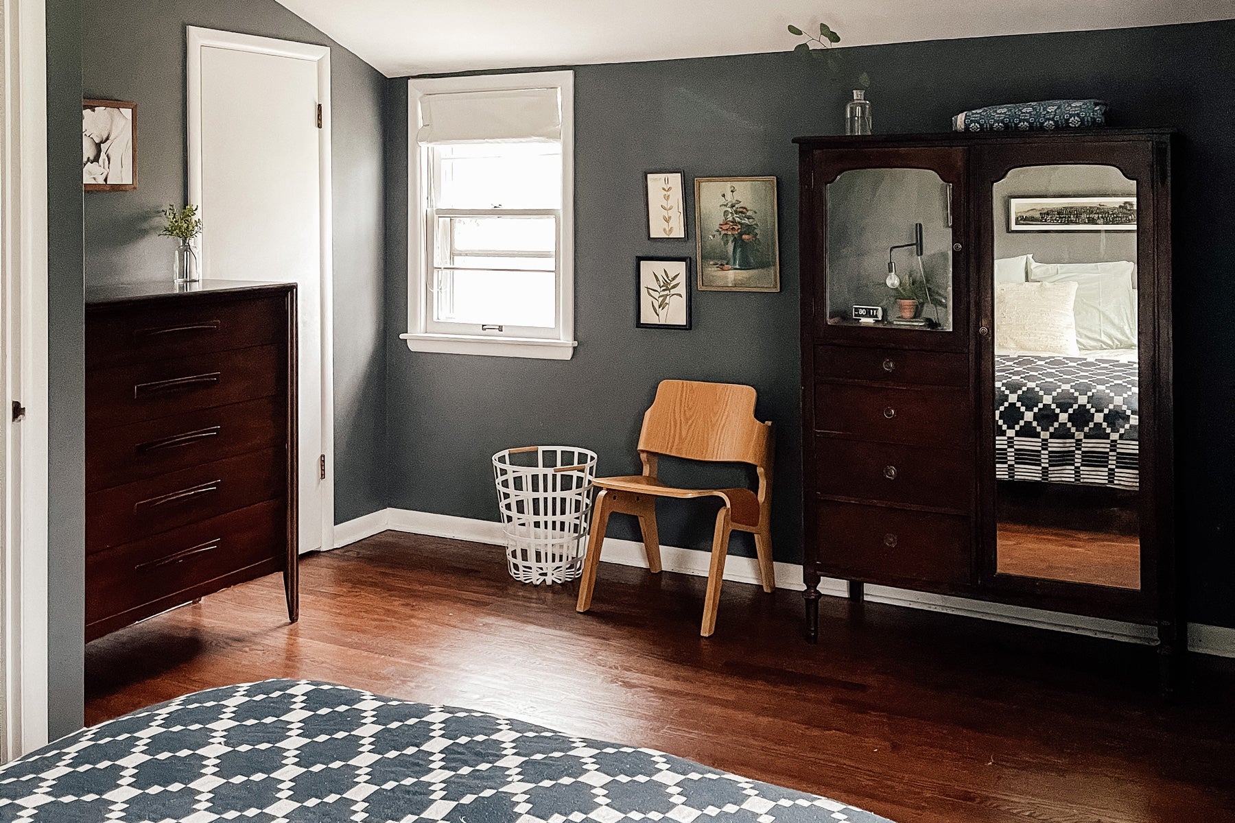 room with a chair and a dresser and mirror