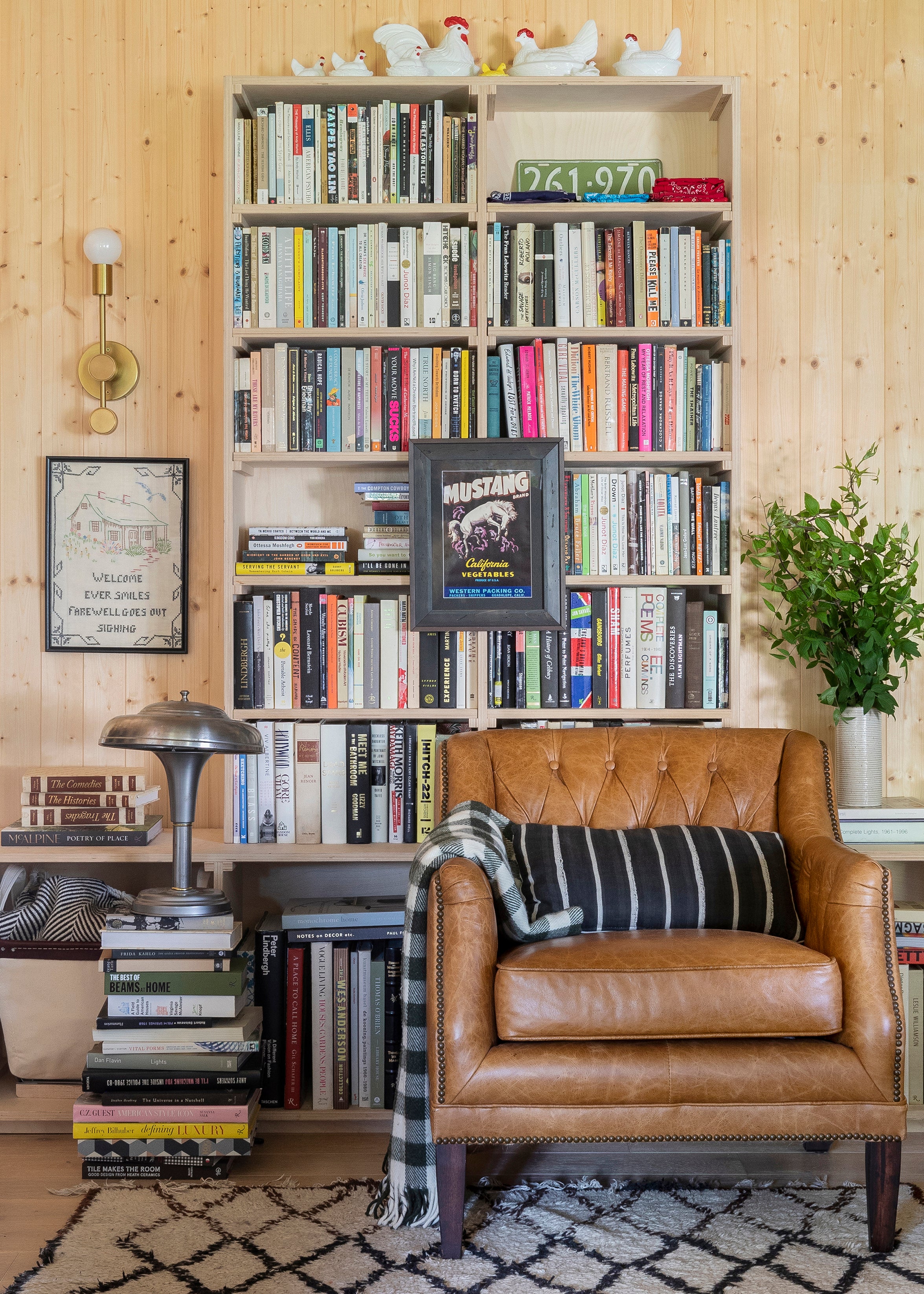 chair in front of a bookcase and a plant