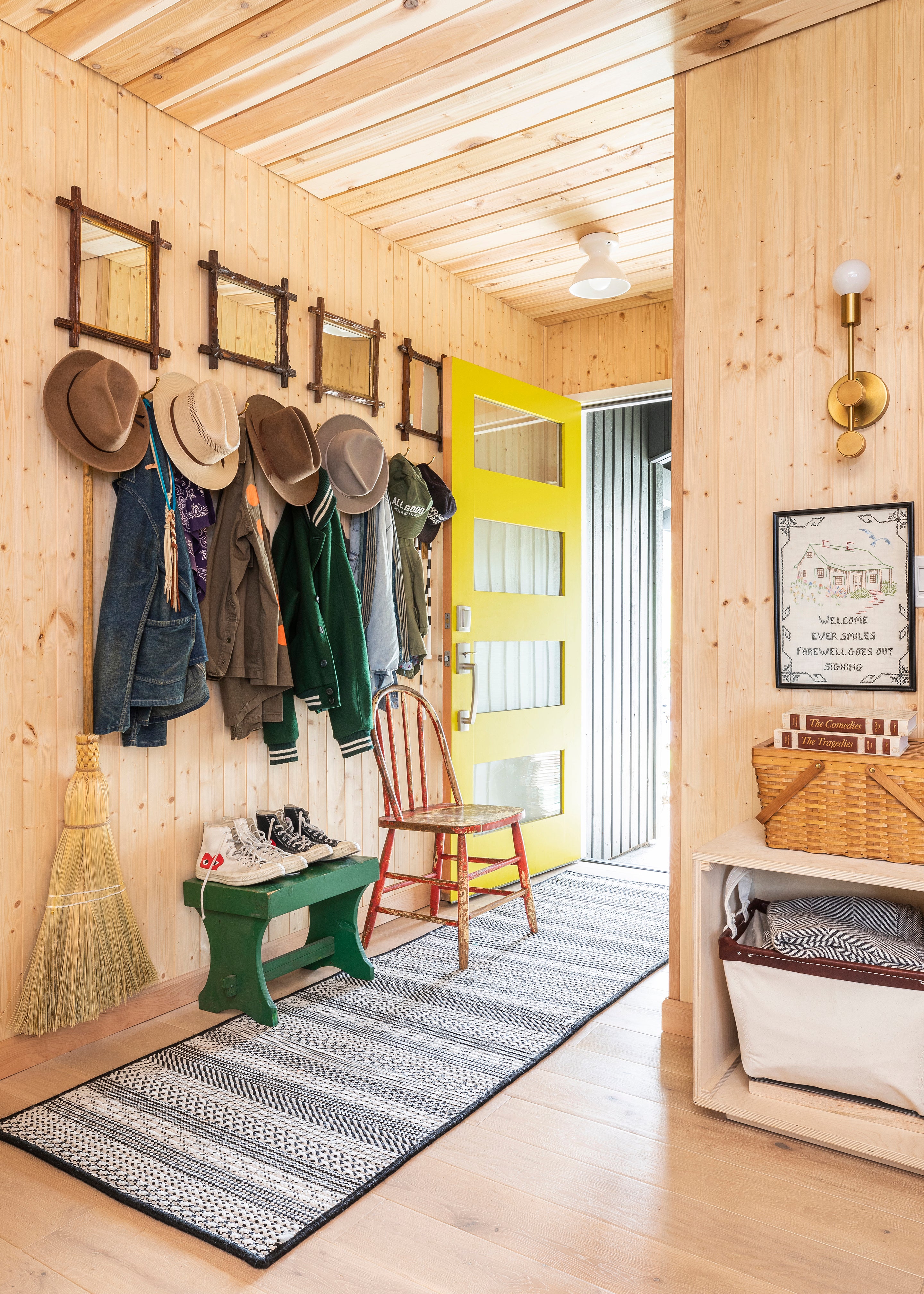 hallway with clothes hanging on hooks and a rug