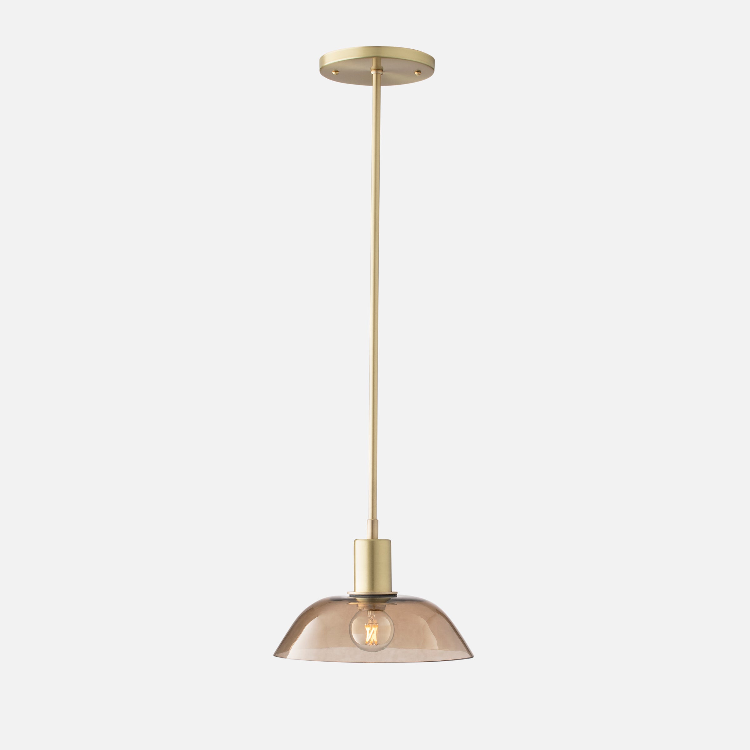 Gillespie pendant in natural brass with a glass shade.