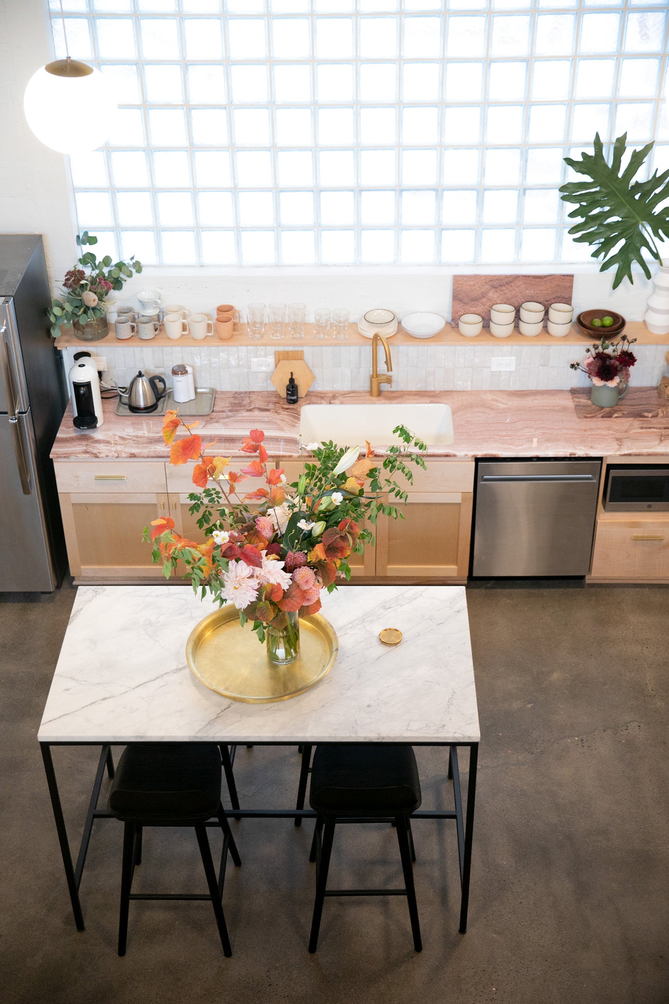 kitchen with a table and chairs with a large vase of colorful flowers