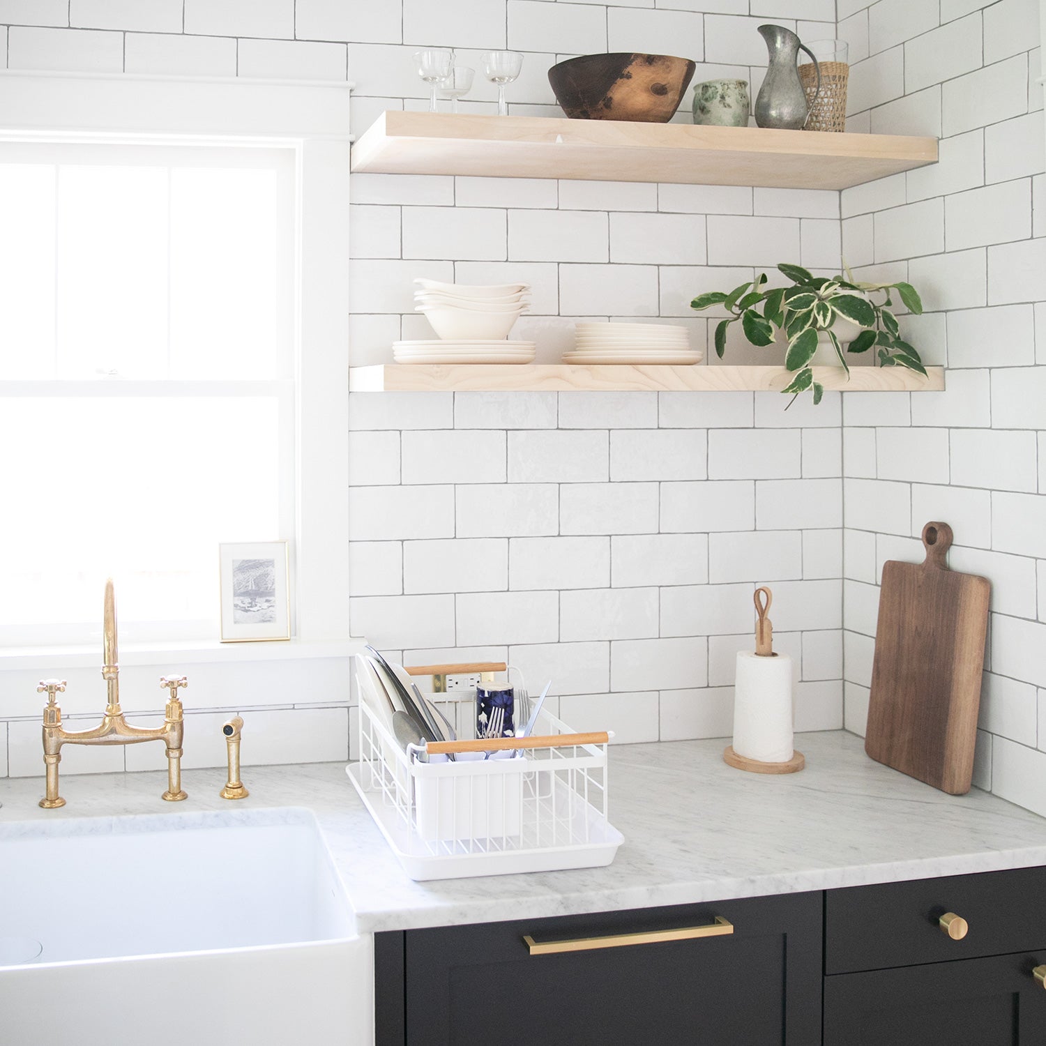 kitchen with white tiles and black cabinets and shelves