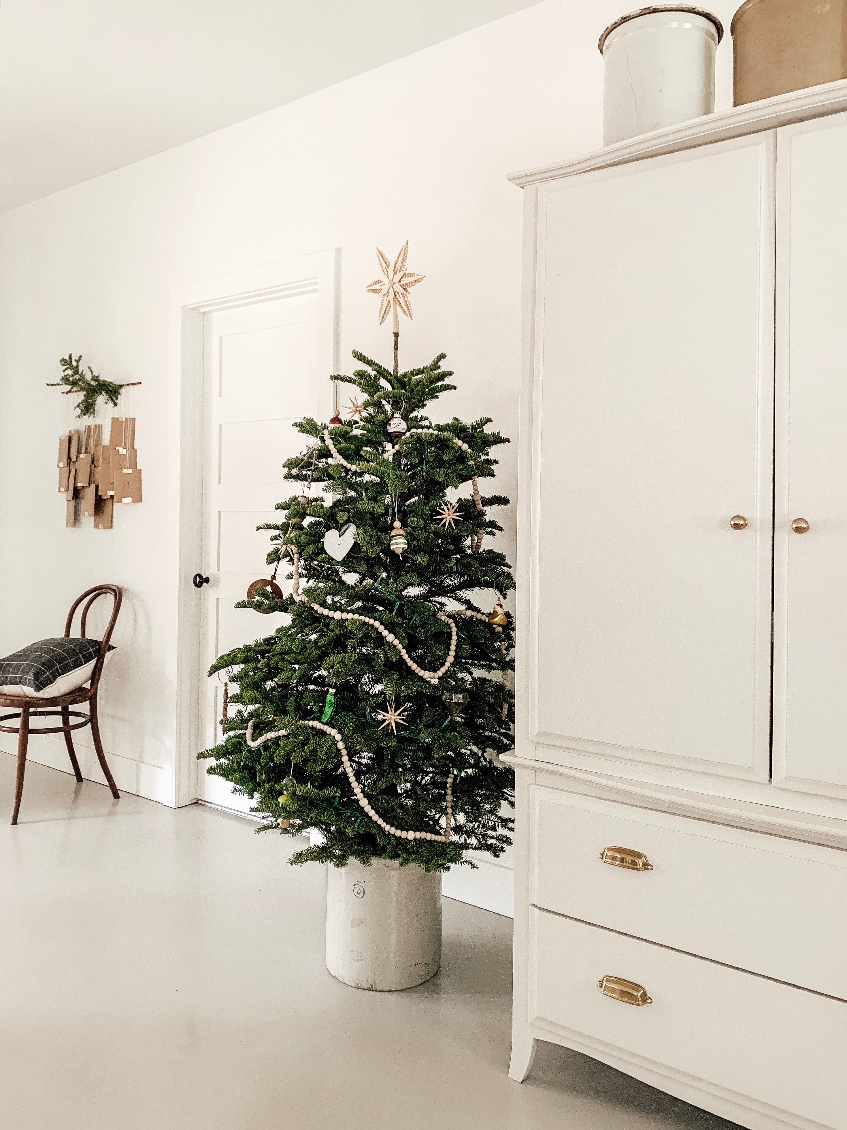 christmas tree next to a cabinet