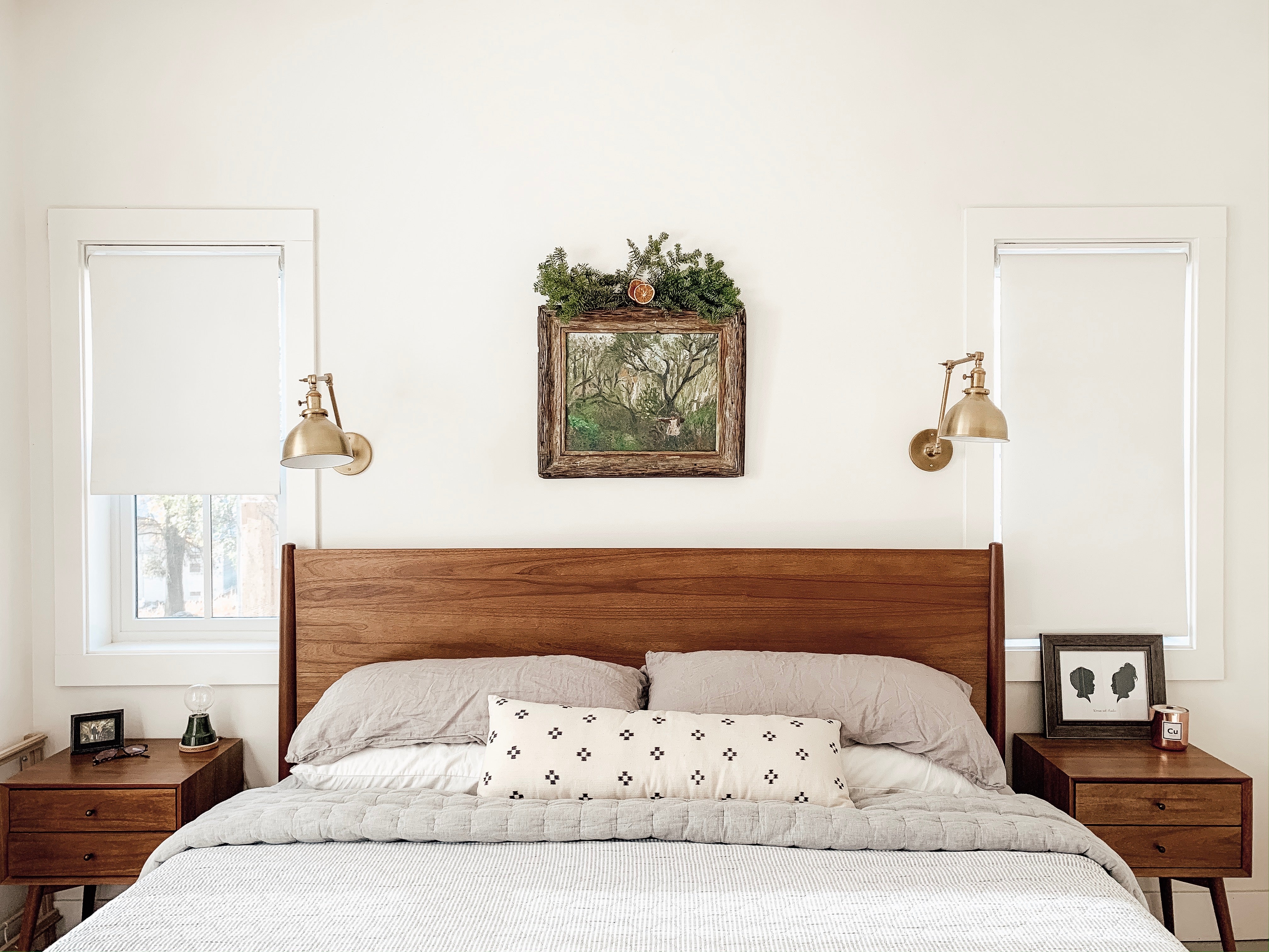 bed with a wooden headboard and a framed art piece above it