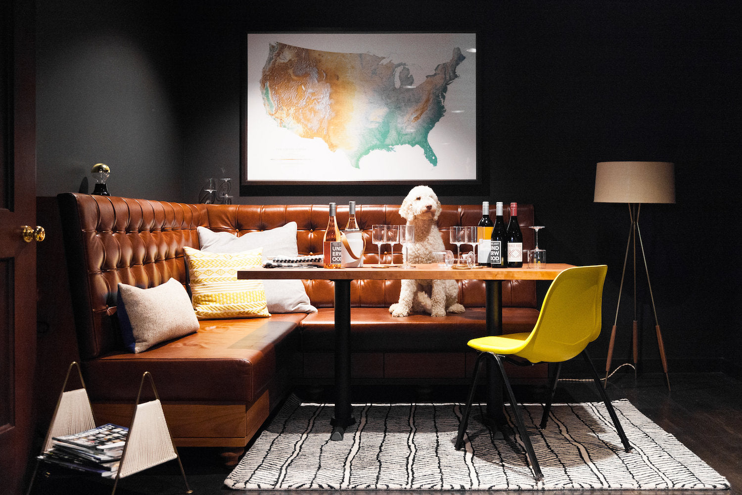 room with a table and white dog and map of the united states on the wall