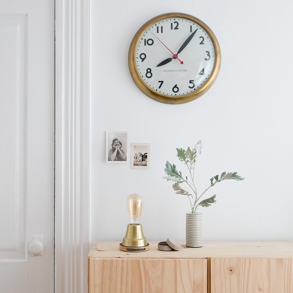 clock on a wall and a lamp on a cabinet