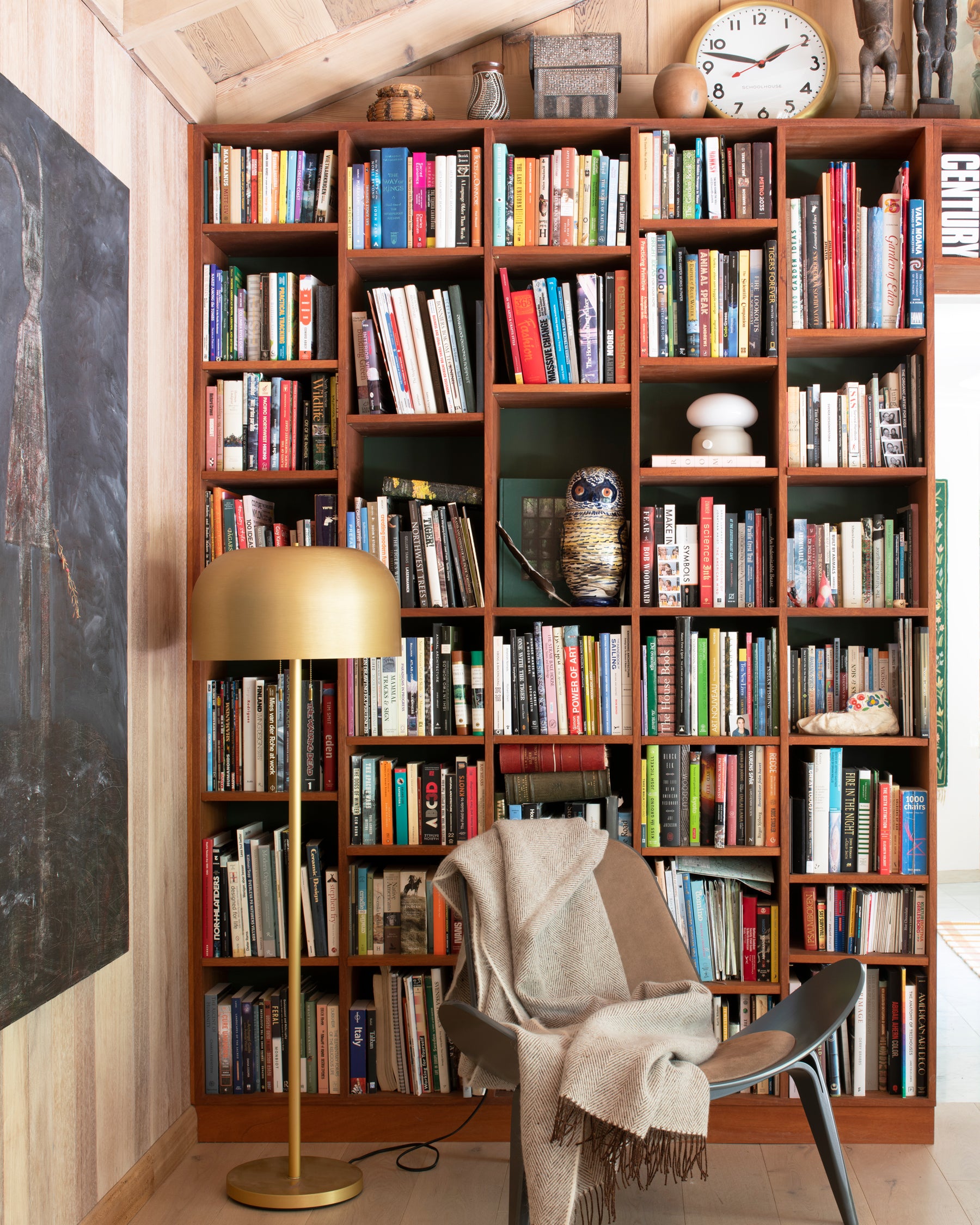 chair and gold floor lamp in front of a bookshelf