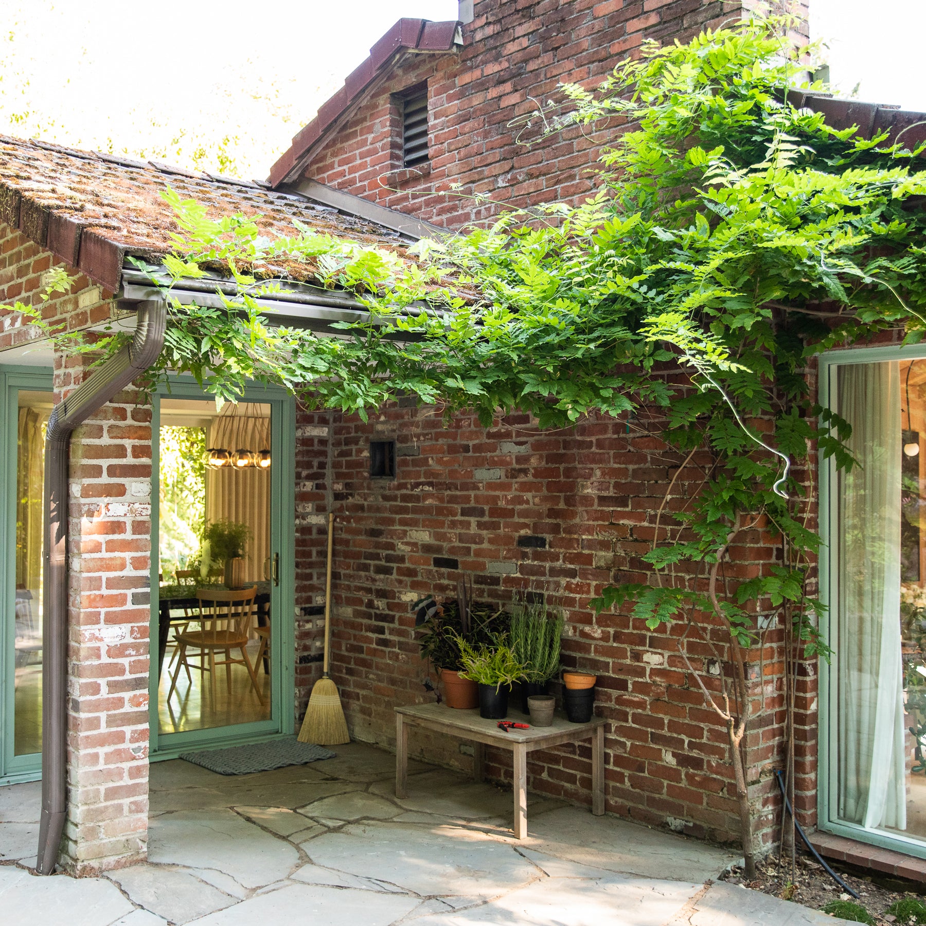 brick building with a table and chairs outside and a tree