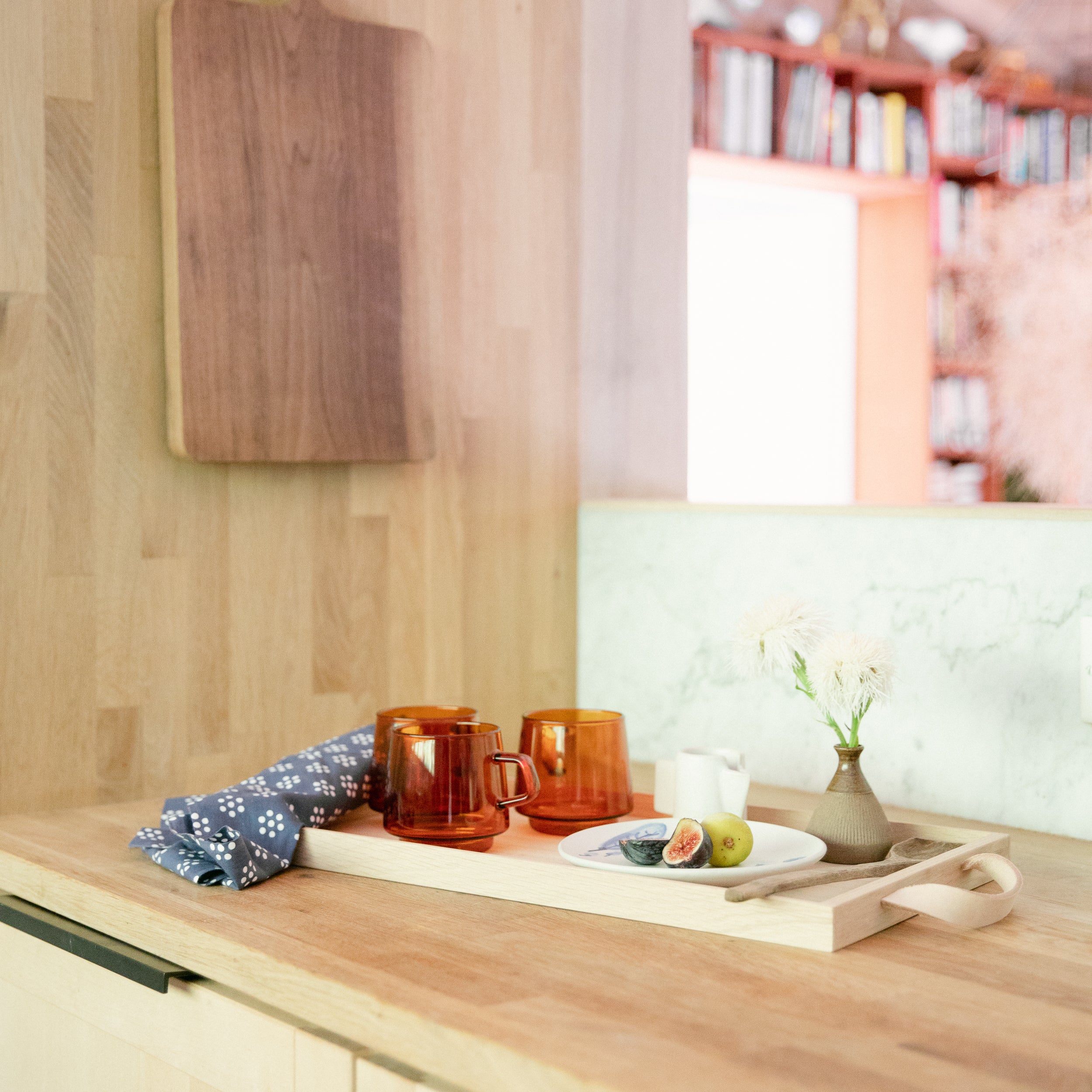 wooden counter with a wooden tray and cups on it