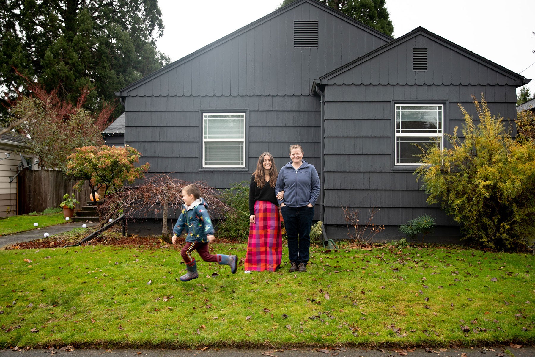 family posing in front of a house