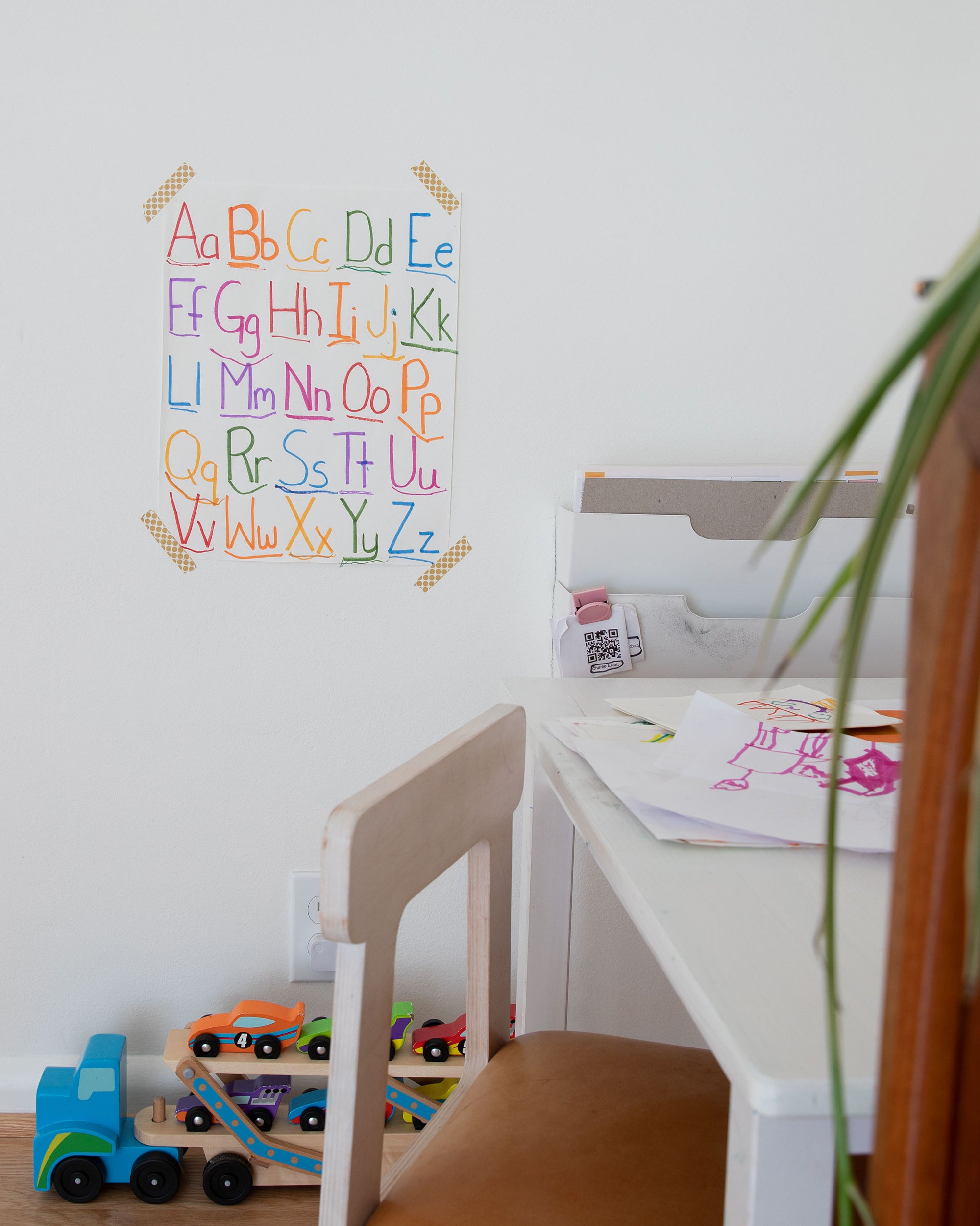 chair and table and toys and child's drawing on wall