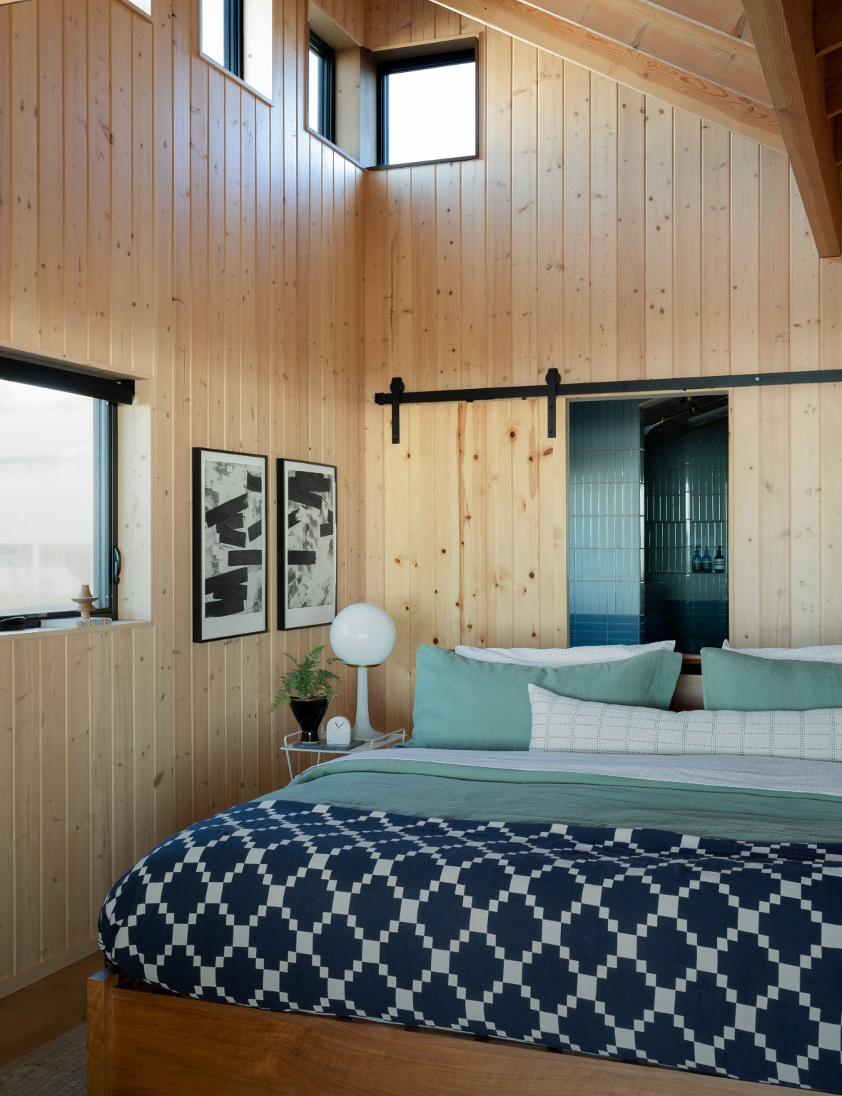 Wood paneled bedroom with blue bedding on bed. 