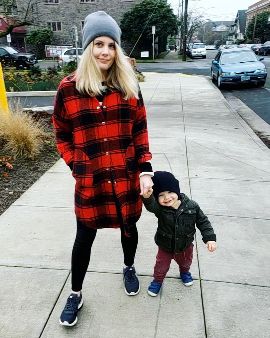 person and a child walking on a sidewalk