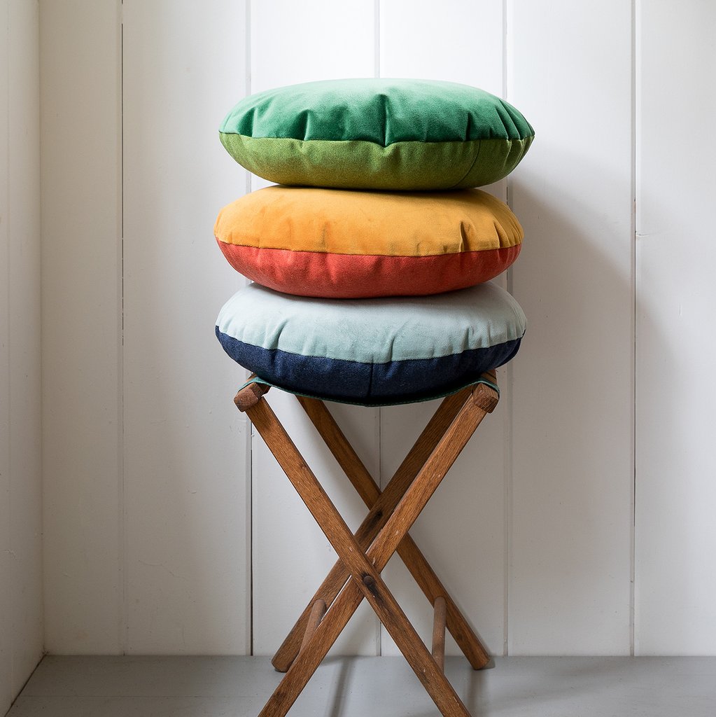 stool with a stack of colorful round pillows on it