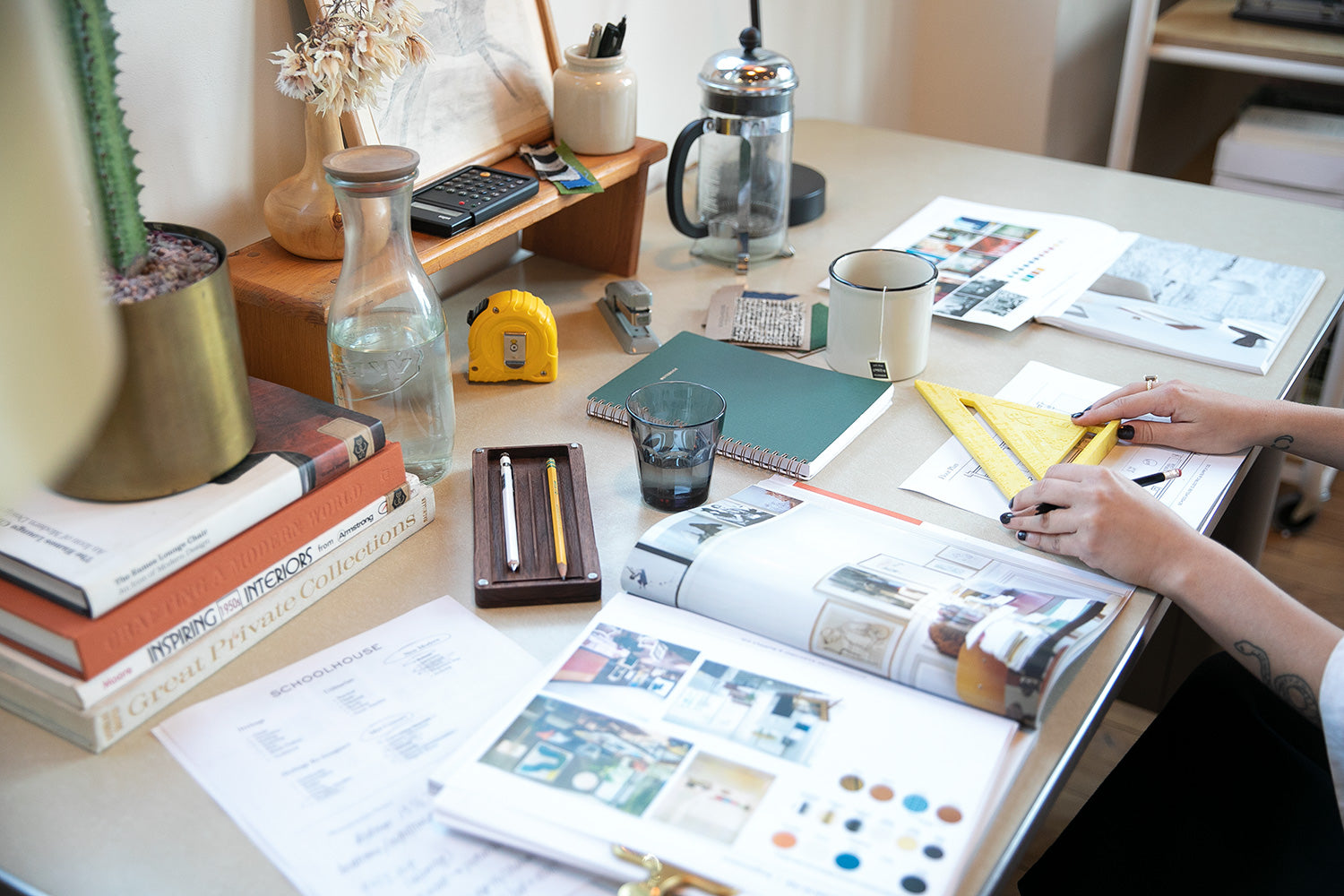 person sitting at a table with papers and a vase with flowers